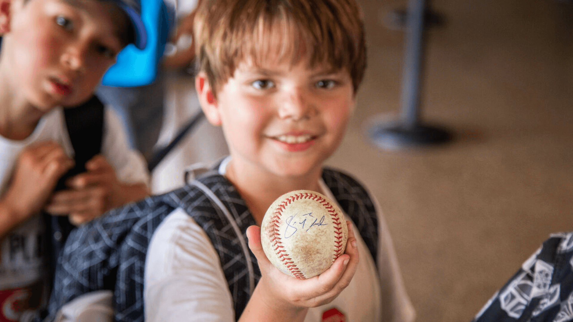 Child with autographed baseball from Charlotte Knights player