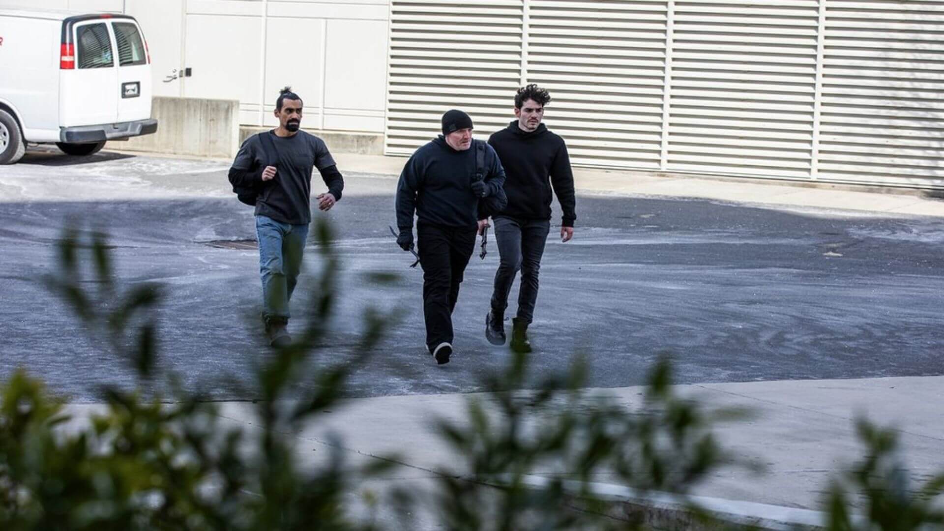 Three burglars approaching a business